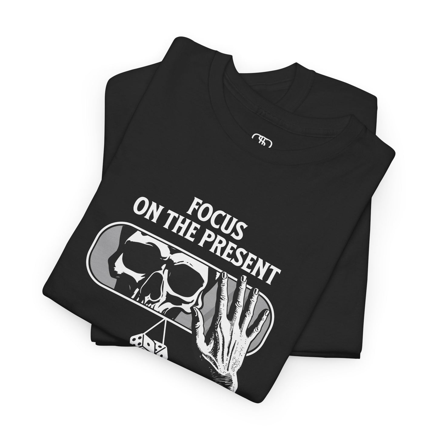 A t-shirt graphic folded of a car's rearview mirror reflecting a skeleton's face. A living hand reaches toward the mirror, which has dice dangling from it. The phrase “Focus on the present” is part of the design.