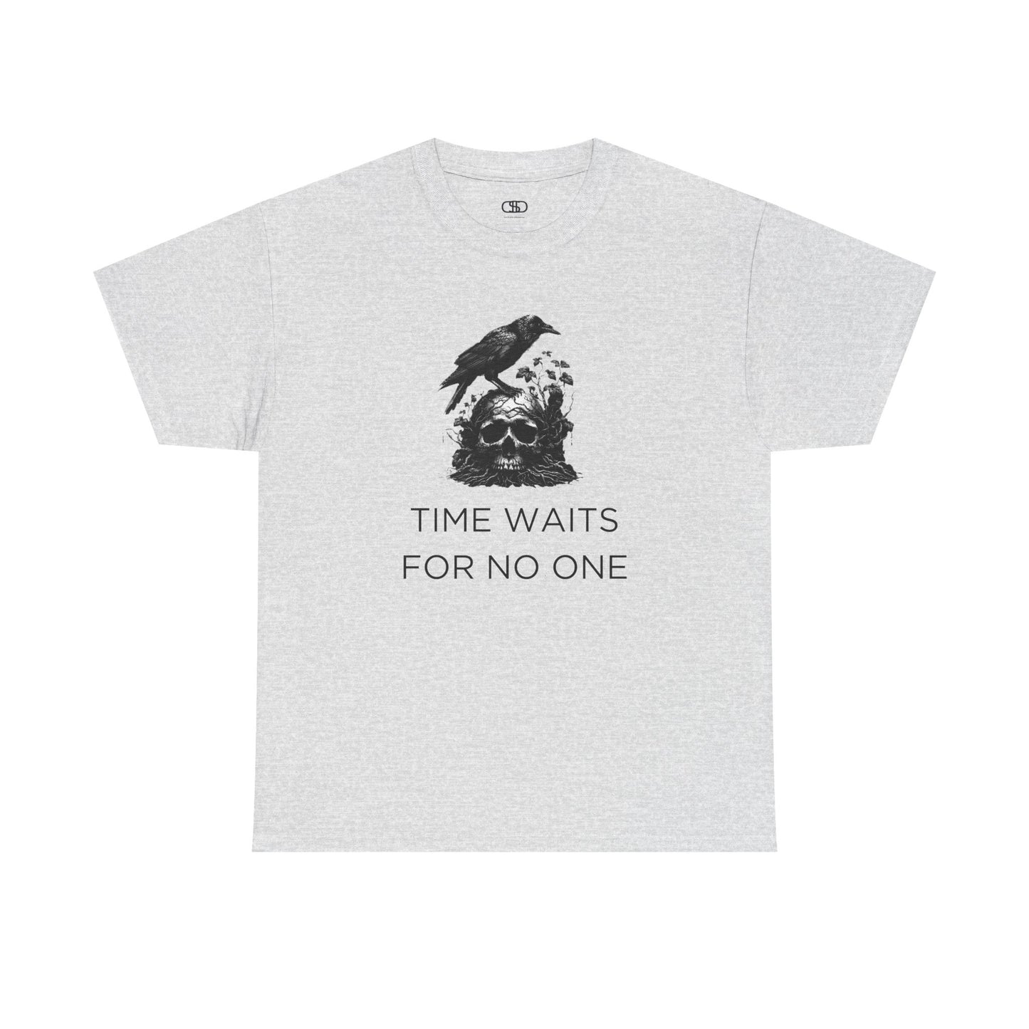 A close-up of a t-shirt with a gothic illustration. A black crow stands atop a weathered skull, which has moss and delicate vines growing through its eye sockets and around its form, blending nature and death.