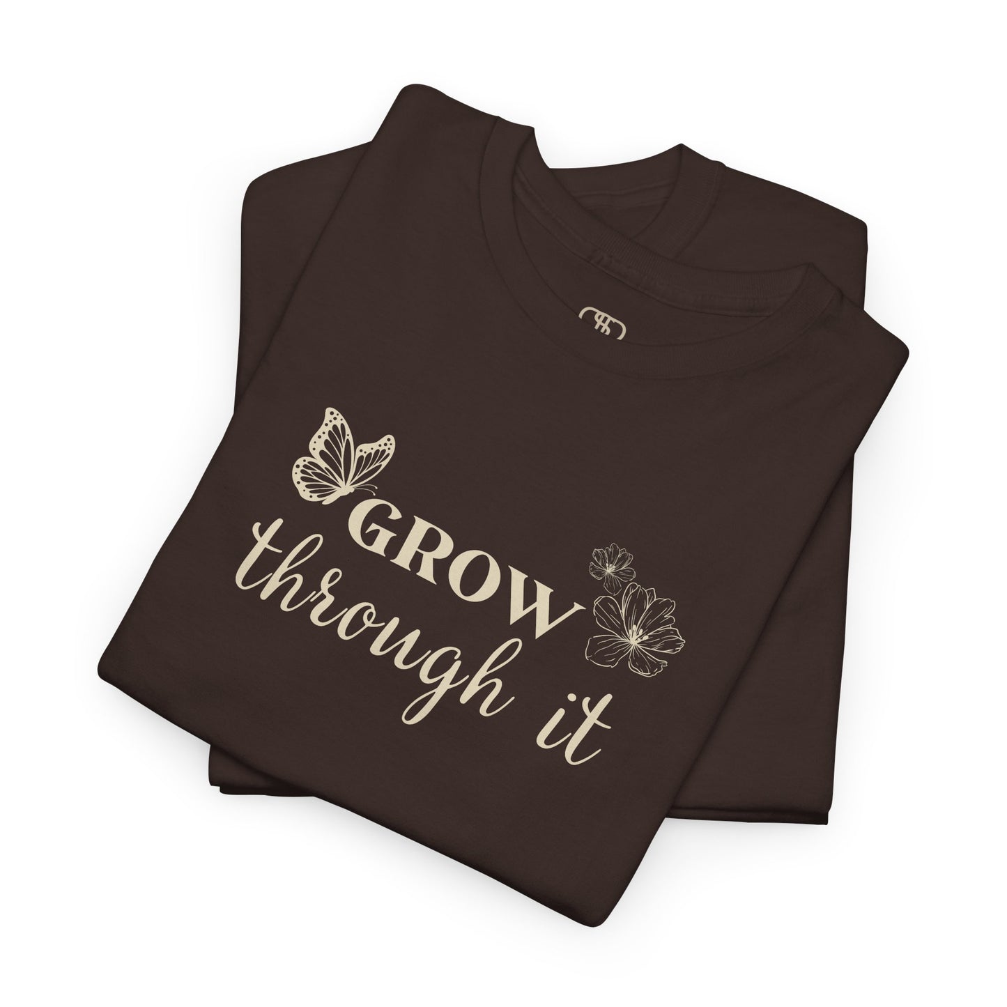 A folded dark brown t-shirt with "Grow Through It" and a butterfly on the front and a design of a spine with vines, flowers, and butterflies on the back.