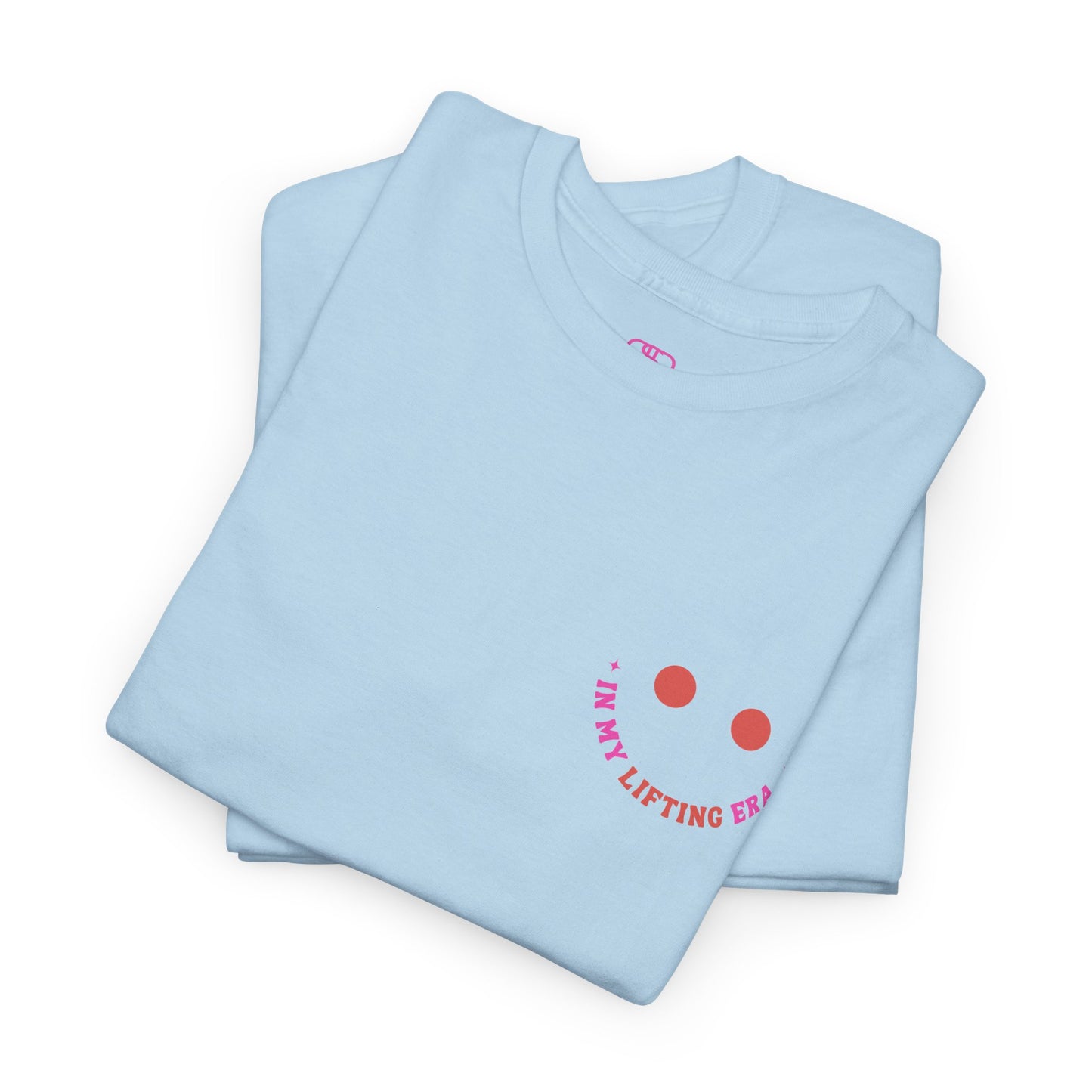 A folded light blue t-shirt with a retro smiley face on the front and the phrase “In my lifting Era” in a creative retro design on the back.