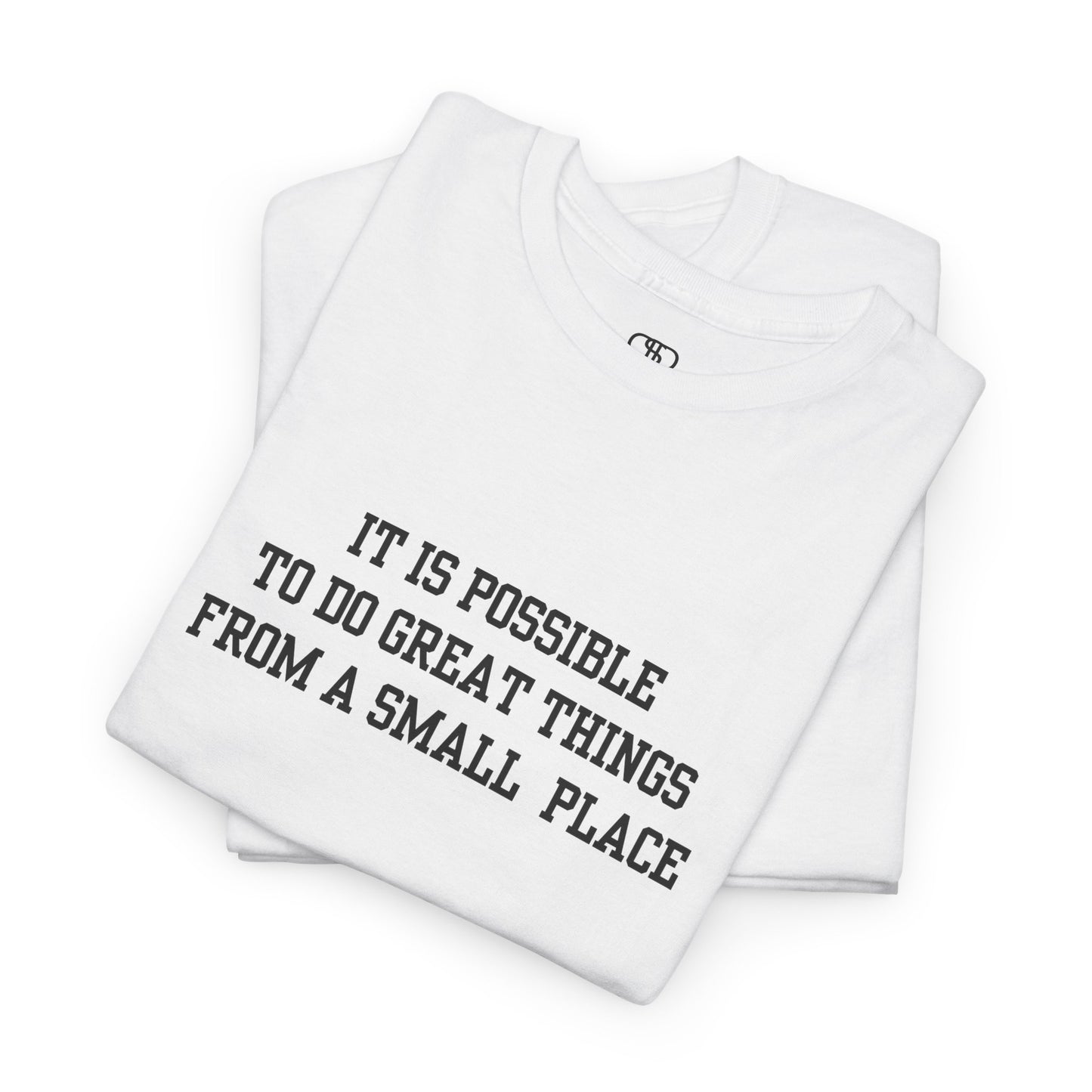 A folded white t-shirt with the quote “It is possible to do great things from a small place” on the front.