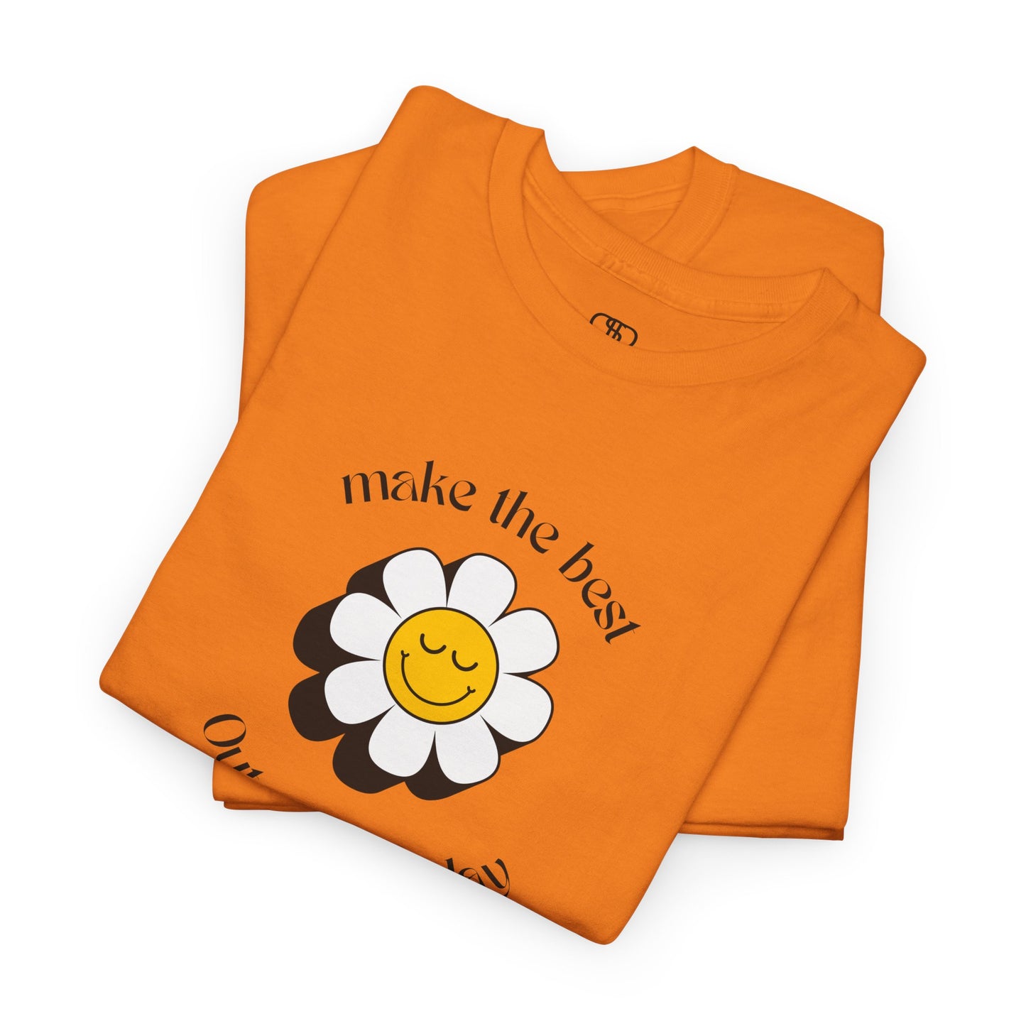 A folded orange t-shirt with a smiling sunflower and the words “Make the best out of Everyday” on the front and “Dear Person behind me, I’m glad that you are here” on the back.