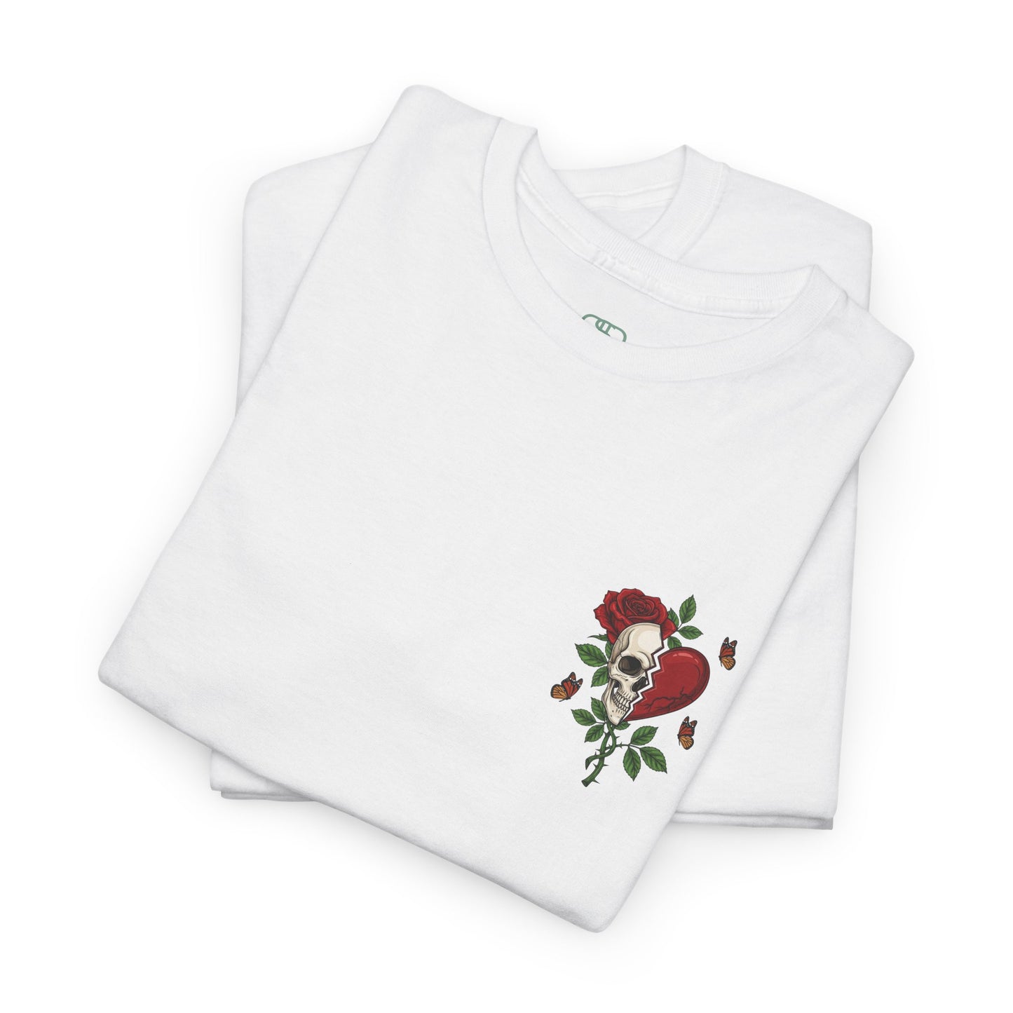 A folded white t-shirt with a front design of a half skull, half broken heart, and a rose. The back reads "Gym Heals" in red.