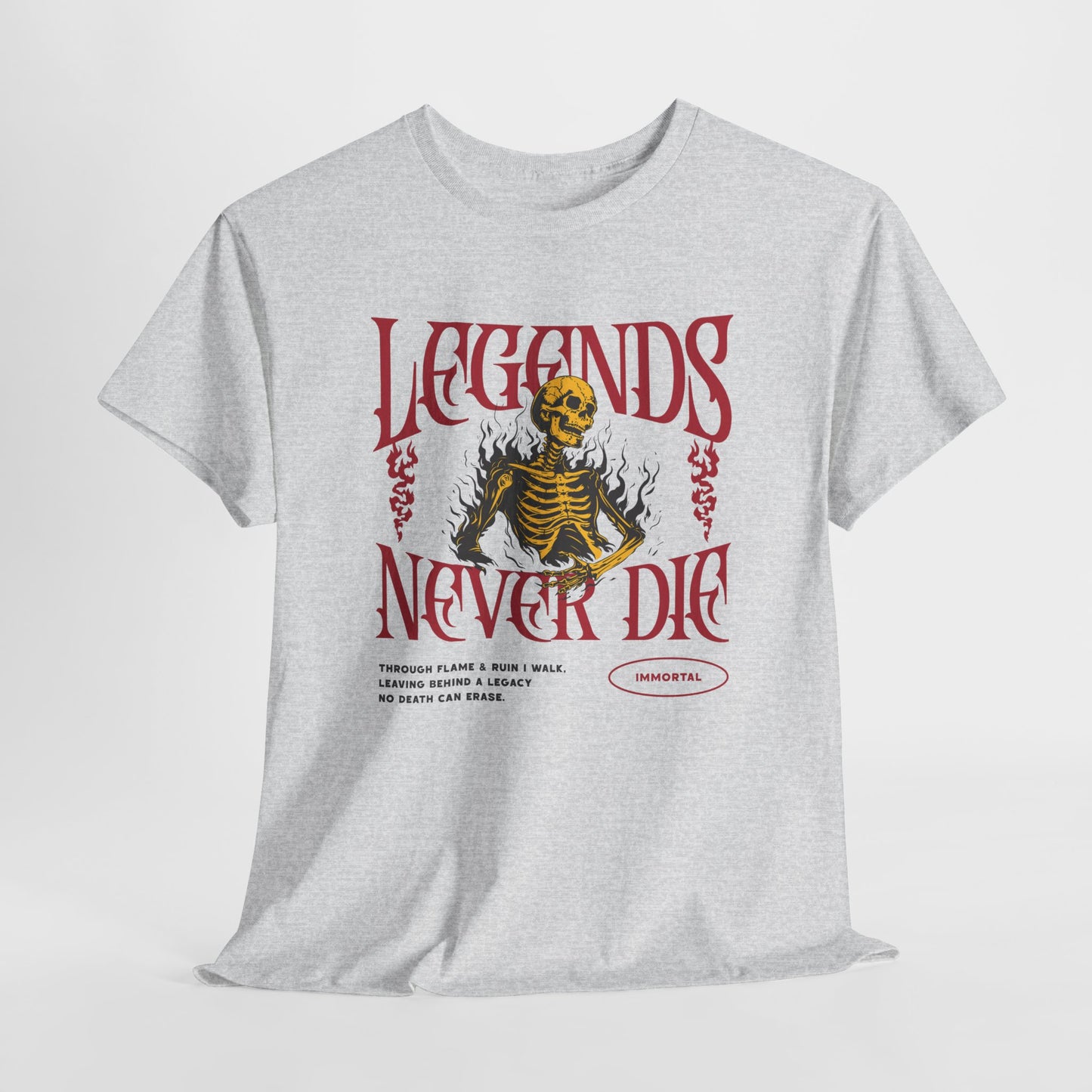 An ash gray t-shirt with a graphic of a defiant skeleton engulfed in flames. The words “Legends Never Die” are prominently displayed, with a smaller quote and the word “Immortal” included in the design.
