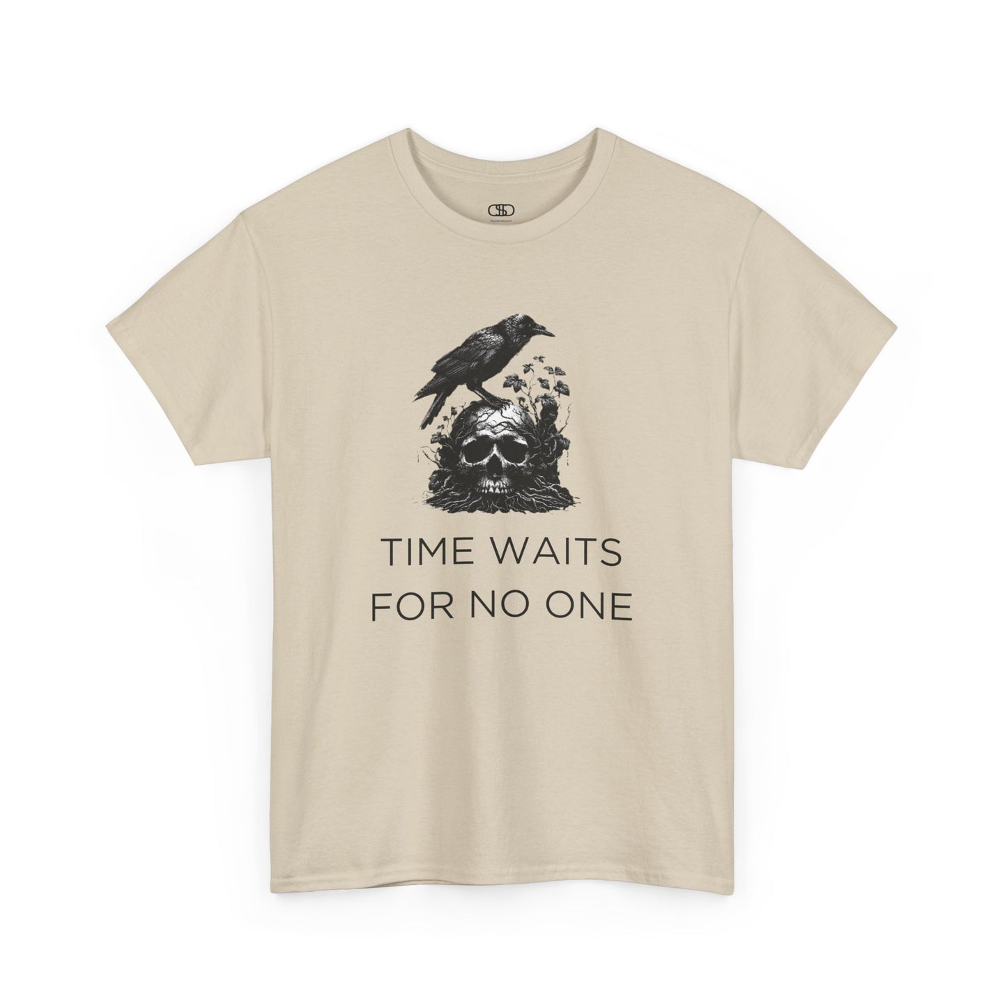 A close-up of a t-shirt with a gothic illustration. A black crow stands atop a weathered skull, which has moss and delicate vines growing through its eye sockets and around its form, blending nature and death.