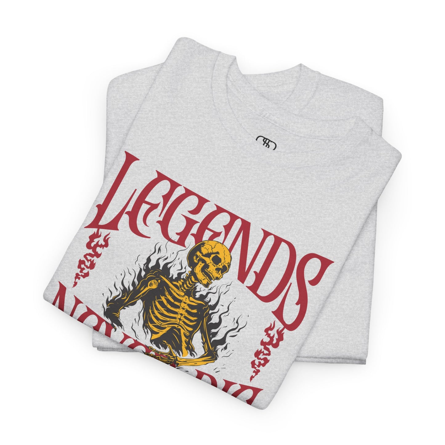 A folded ash gray t-shirt with a graphic of a defiant skeleton engulfed in flames. The words “Legends Never Die” are prominently displayed, with a smaller quote and the word “Immortal” included in the design.