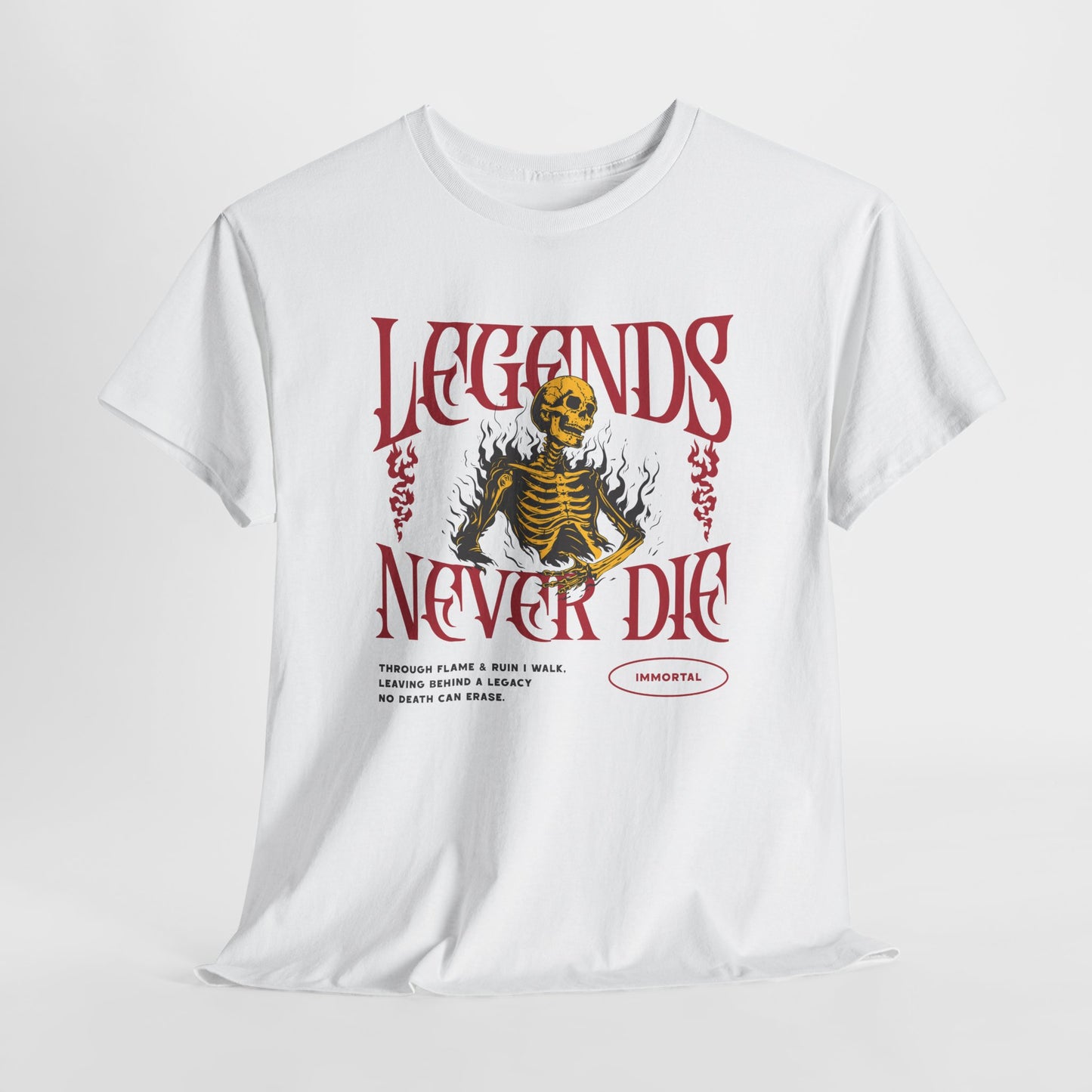 A white t-shirt with a graphic of a defiant skeleton engulfed in flames. The words “Legends Never Die” are prominently displayed, with a smaller quote and the word “Immortal” included in the design.