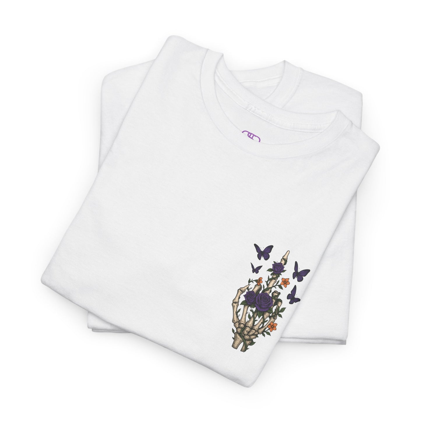 A folded white t-shirt with a skeleton hand flipping its middle finger on the front surrounded by vines, roses, & butterflies, and a full skeleton design on the back with the phrase “My Last Flying Fuck.”