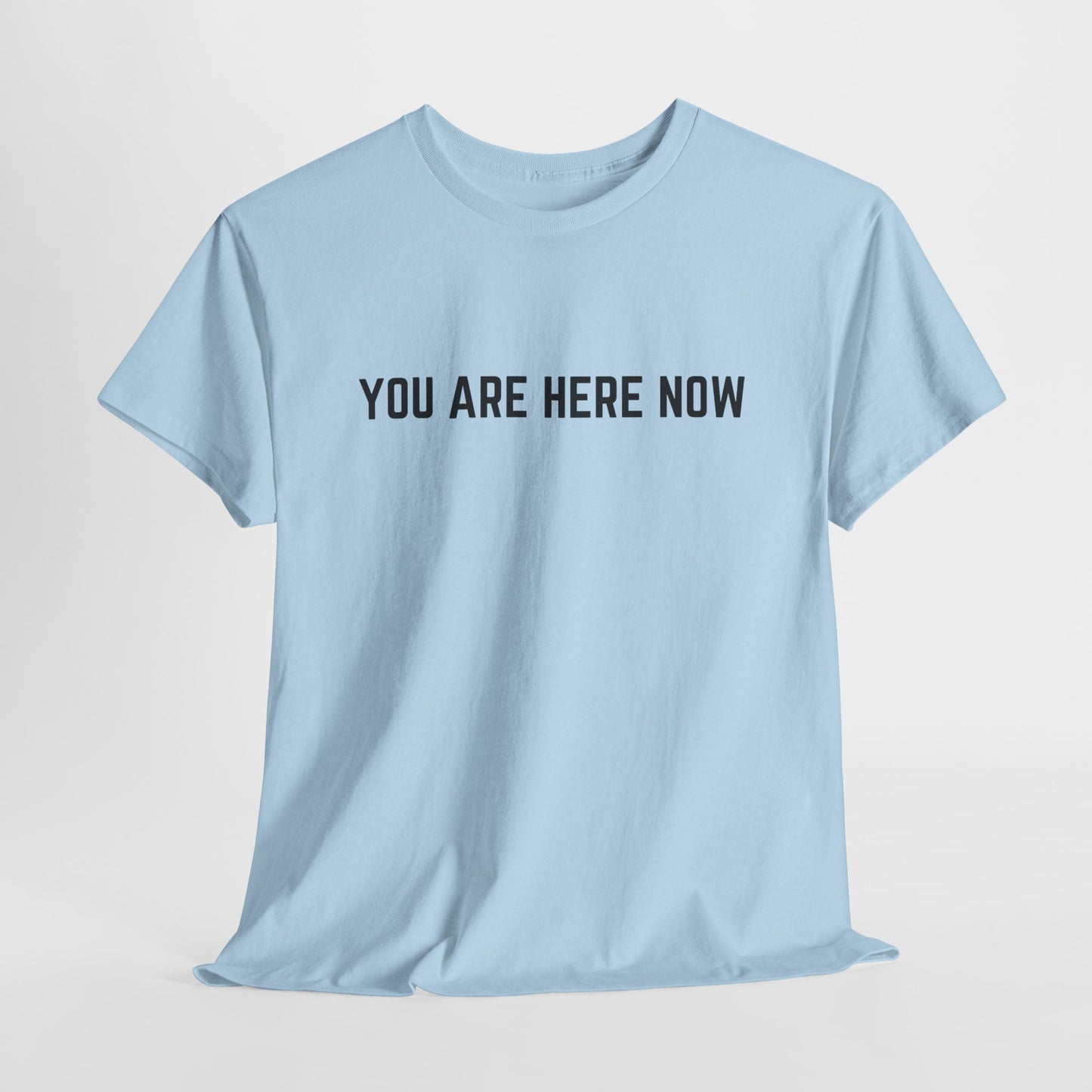 Front of a t-shirt with the grounding phrase "You are Here now" in a clean, minimalist font.