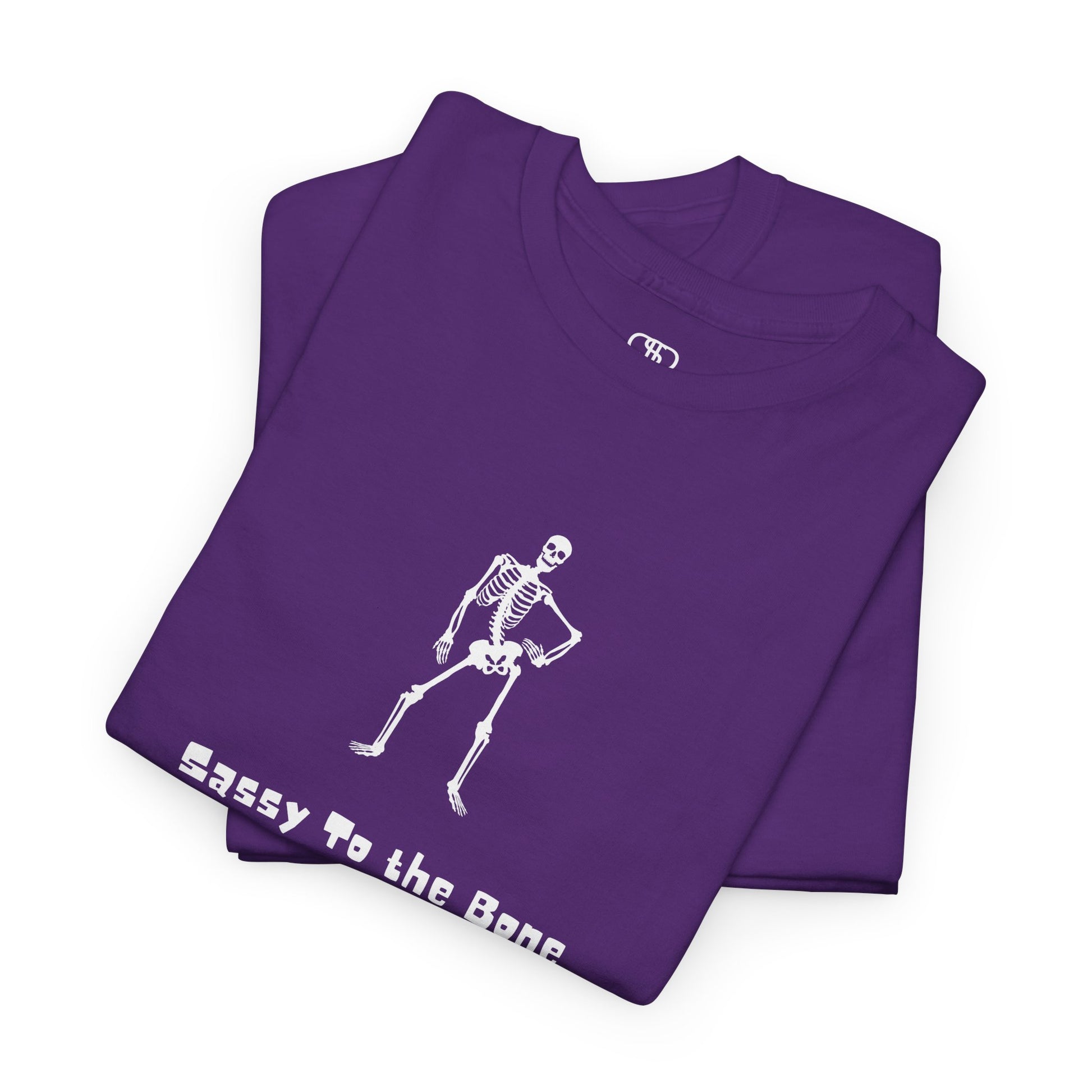 Folded  T-shirt with a sassy skeleton graphic with hands on hips and "Sassy to the Bone" text in a cartoon font.