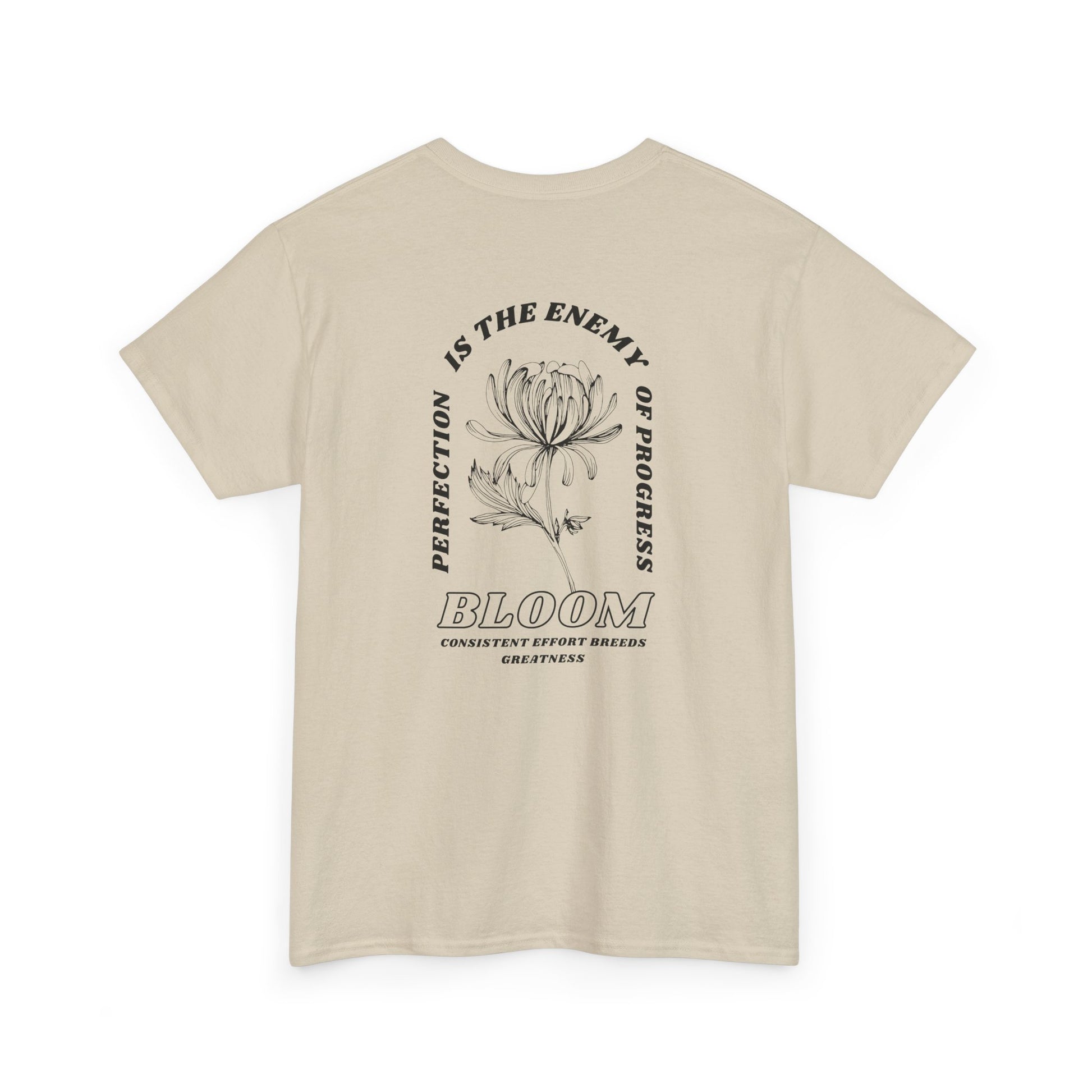 A [sand] t-shirt with a central flower design and the words “Perfection is the enemy of progress” and “Bloom” underneath it the phrase "Consistent effort breeds greatness," featured on the back of the t-shirt.