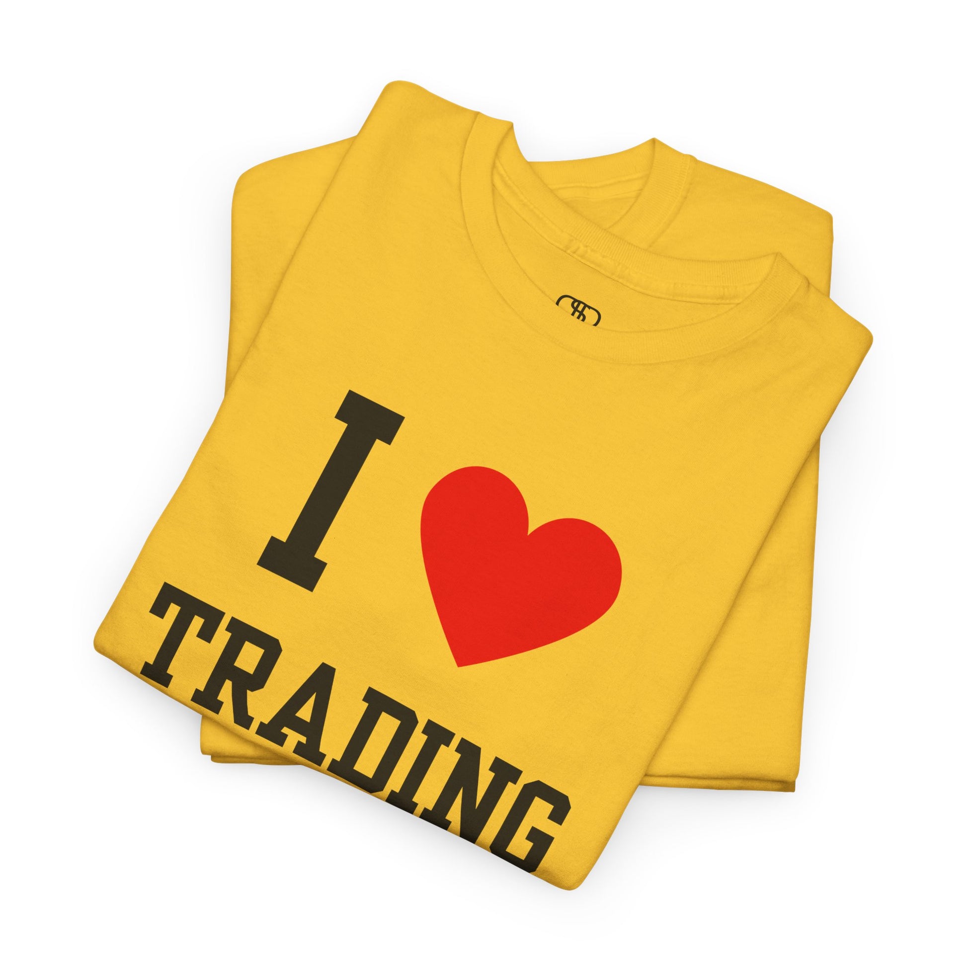 A minimalist yellow folded t-shirt featuring the "I Love  design with the text "I," a red heart symbol, and the word "Trading" underneath.