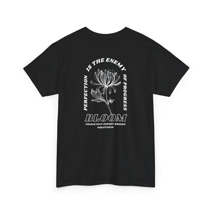 A [black] t-shirt with a central flower design and the words “Perfection is the enemy of progress” and “Bloom” underneath it the phrase "Consistent effort breeds greatness," featured on the back of the t-shirt.