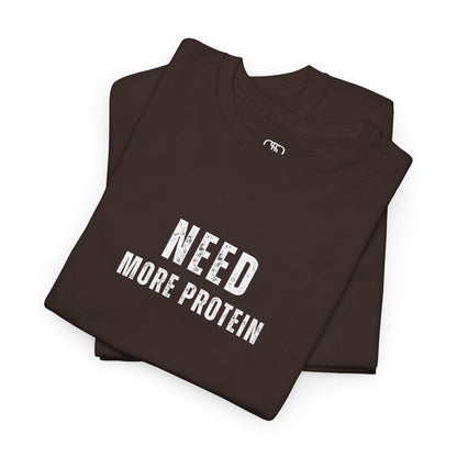 A folded dark brown t-shirt with the words “Need Protein” in a large grunge font.