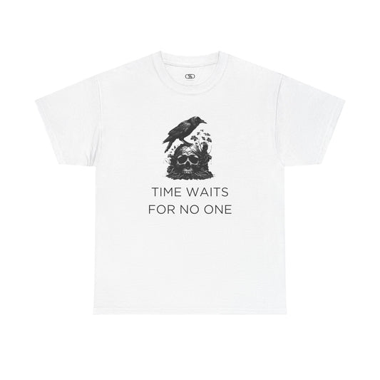 A close-up of a t-shirt with a gothic illustration. A black crow stands atop a weathered skull, which has moss and delicate vines growing through its eye sockets and around its form, blending nature and death.