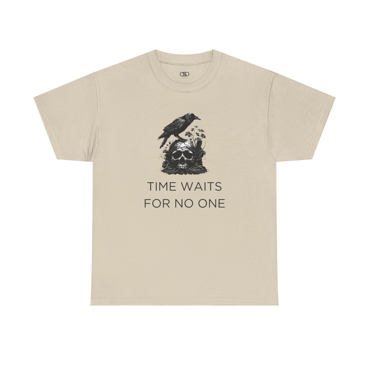 A close-up of a t-shirt with a gothic illustration. A black crow stands atop a weathered skull, which has moss and delicate vines growing through its eye sockets and around its form, blending nature and death.