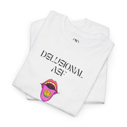 A folded white T-shirt with "Delusional asf" text, an open mouth graphic with tongue out, and a happy face emoji pill.