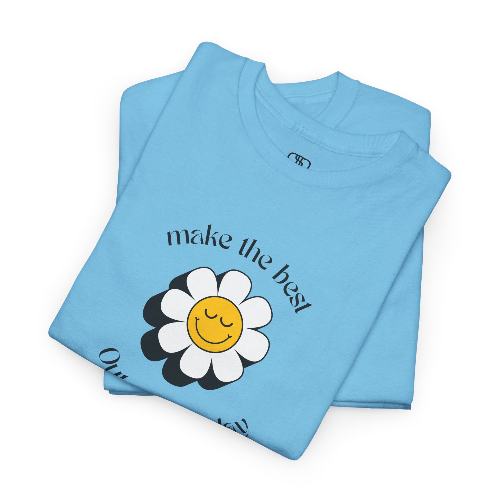 A folded sky blue t-shirt with a smiling sunflower and the words “Make the best out of Everyday” on the front and “Dear Person behind me, I’m glad that you are here” on the back.