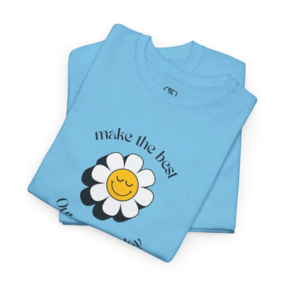 A folded sky blue t-shirt with a smiling sunflower and the words “Make the best out of Everyday” on the front and “Dear Person behind me, I’m glad that you are here” on the back.