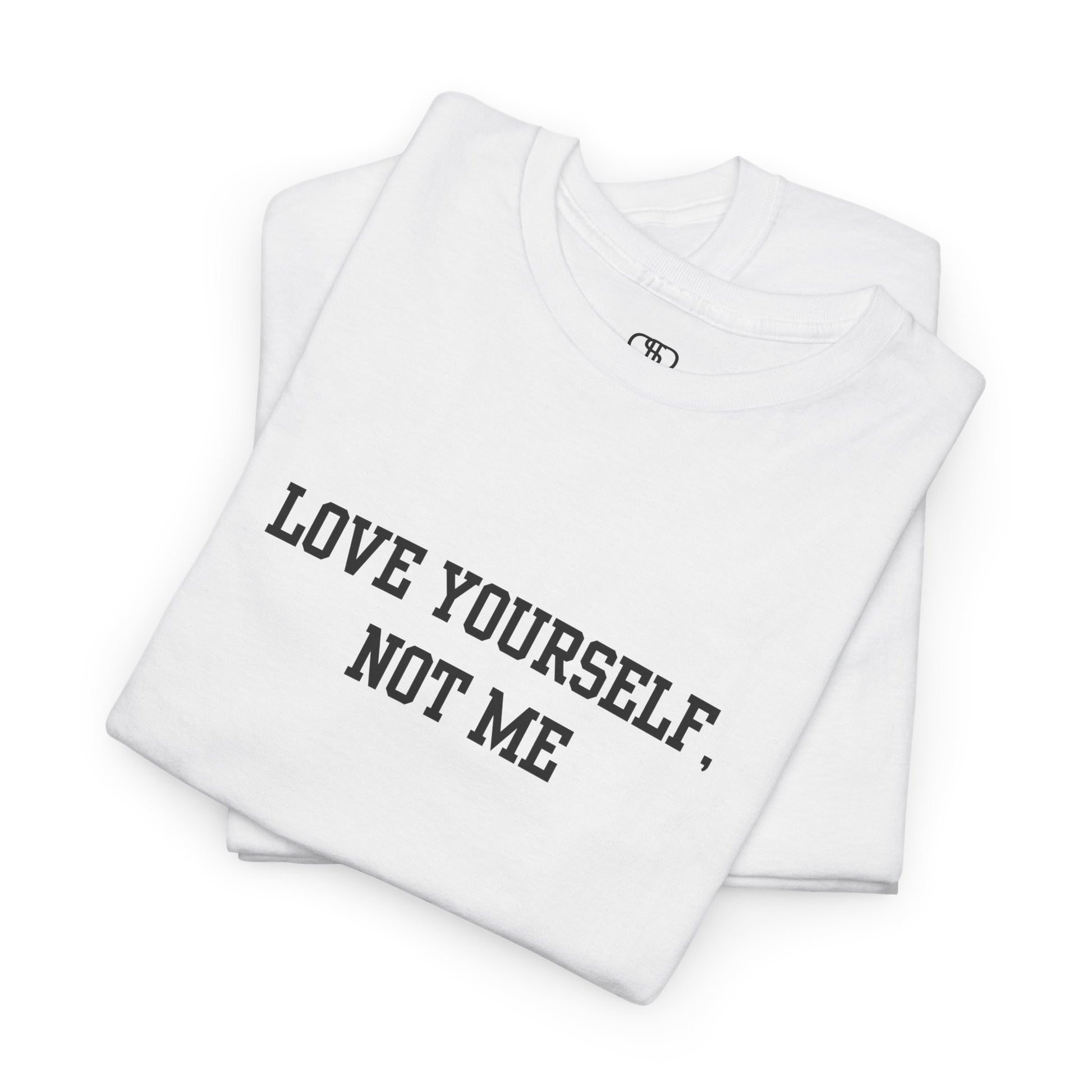 A folded minimalist t-shirt with the bold, centered text "Love yourself, not me" in a clean, modern font.