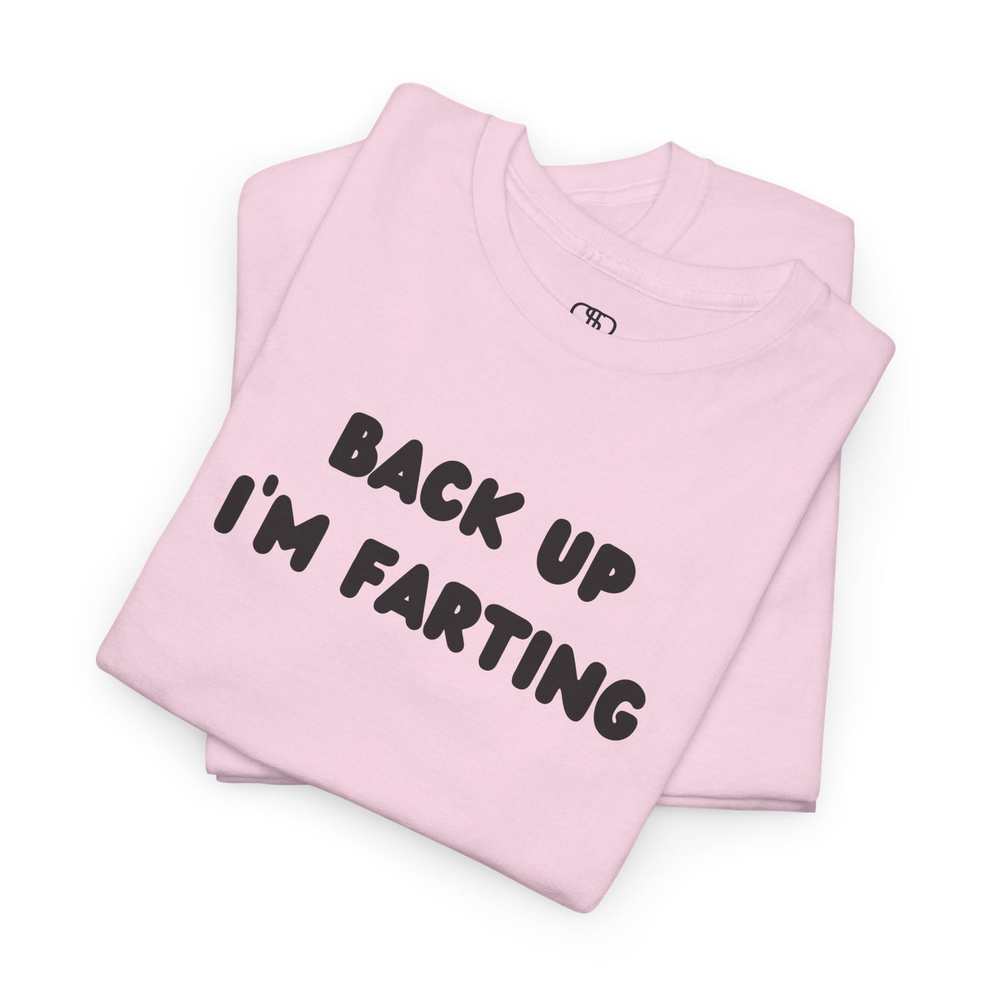 A folded light pink T-shirt with the bold text "Back Up I'm Farting" on the front.
