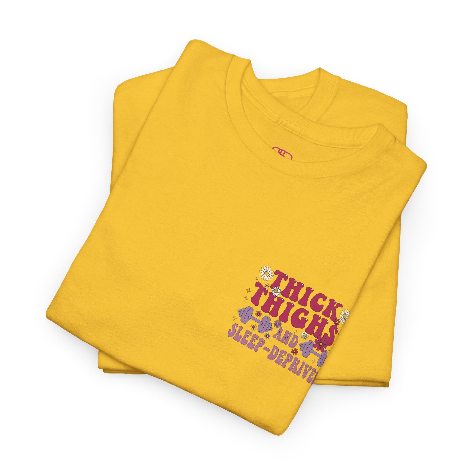 A folded [daisy] t-shirt with the phrase "Thick Thighs and Sleep Deprived" in a retro font on the front left and enlarged on the back.