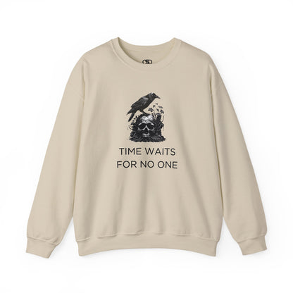 A sweatshirt featuring a detailed illustration of a crow perched on a human skull that is intertwined with overgrown vines and moss. Along with the words Time Waits For No One. 