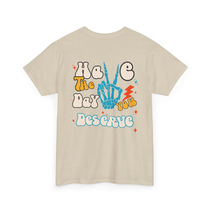 A [sand] t-shirt with a skeletal peace sign on the front and the phrase “Have the day you deserve” with a large skeletal peace sign on the back.