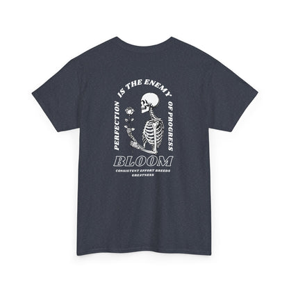 A [navy] t-shirt with a central skeleton and rose design and the words “Perfection is the enemy of progress” and “Bloom” on the front.