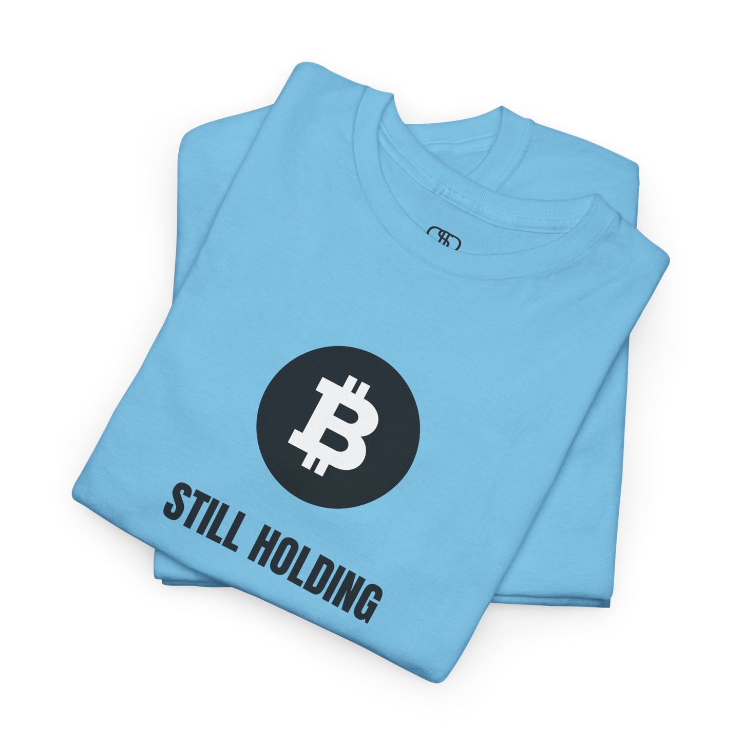 A folded sky blue T-shirt with a Bitcoin emblem and "Still Holding" text in black.