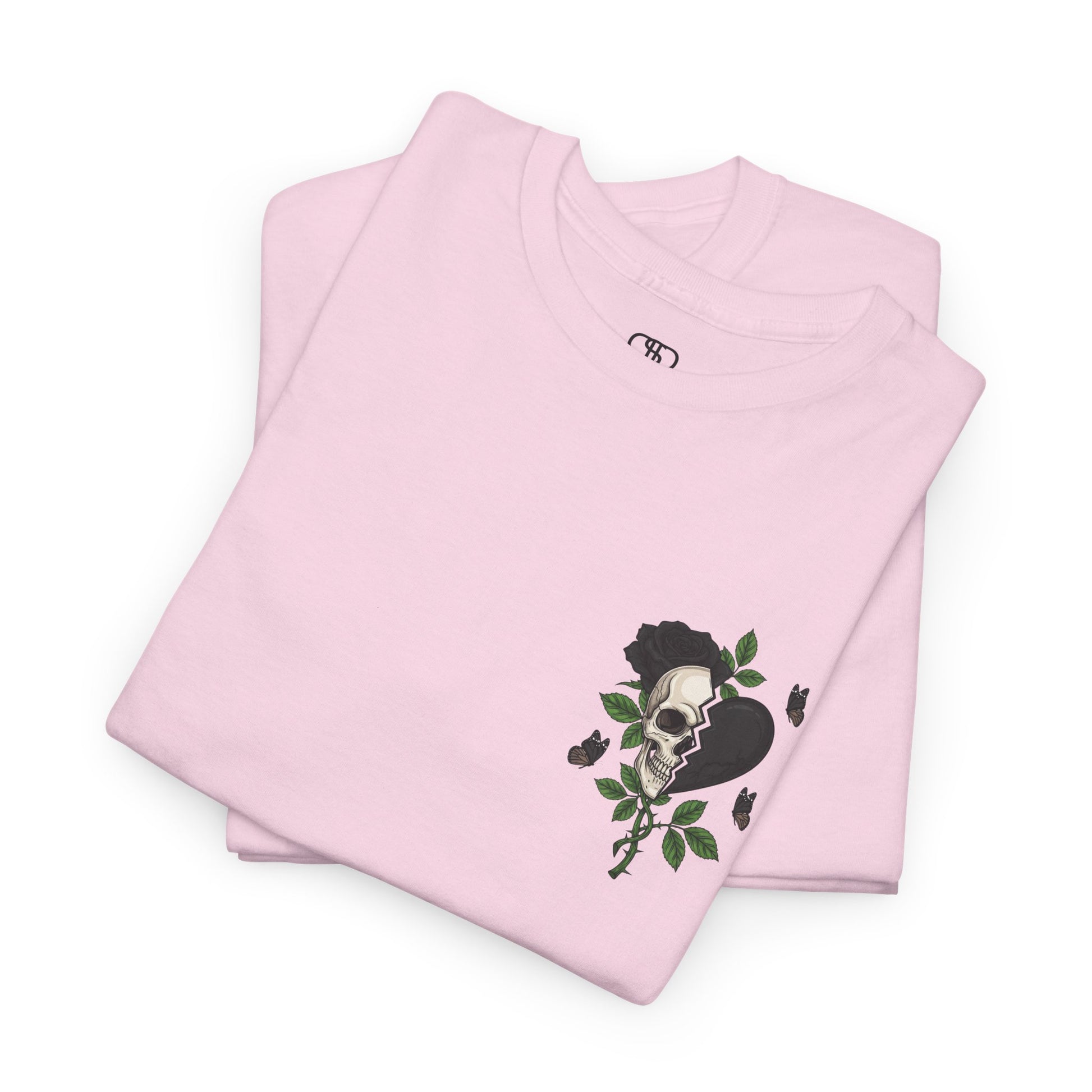 A light pink t-shirt with a front design of a half skull, half broken heart, and a rose. The back reads "Gym Heals" in black.