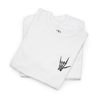 A folded white t-shirt with small rock hand symbol on front, and "Rules.. Never Heard of Them" graffiti text on the back.