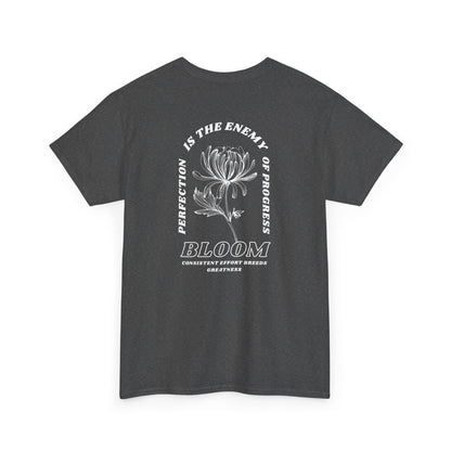 A [heather gray] t-shirt with a central flower design and the words “Perfection is the enemy of progress” and “Bloom” underneath it the phrase "Consistent effort breeds greatness," featured on the back of the t-shirt.