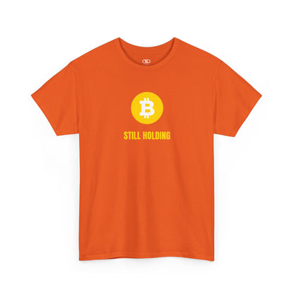 An orange  T-shirt with a Bitcoin emblem and "Still Holding" text in gold.
