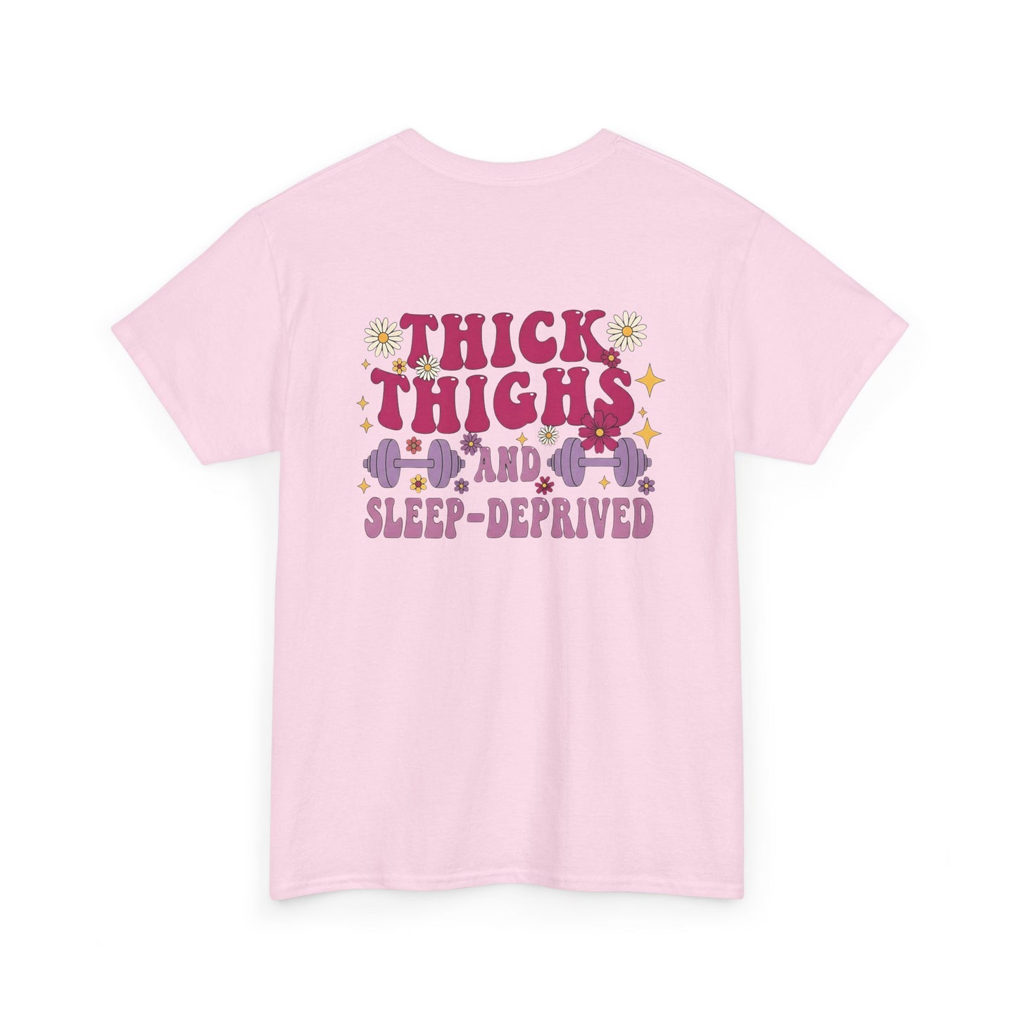 A [light pink] t-shirt with the phrase "Thick Thighs and Sleep Deprived" in a retro font on the front left and enlarged on the back.
