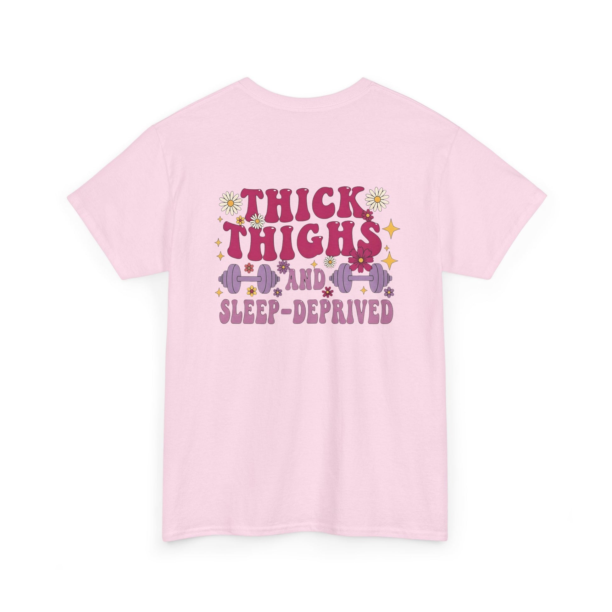 A [light pink] t-shirt with the phrase "Thick Thighs and Sleep Deprived" in a retro font on the front left and enlarged on the back.