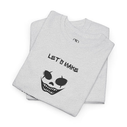 A Folded ash gray T-shirt with a daring clown graphic with sharp teeth and scars, and "Let’s Make Haunting Memories" text.