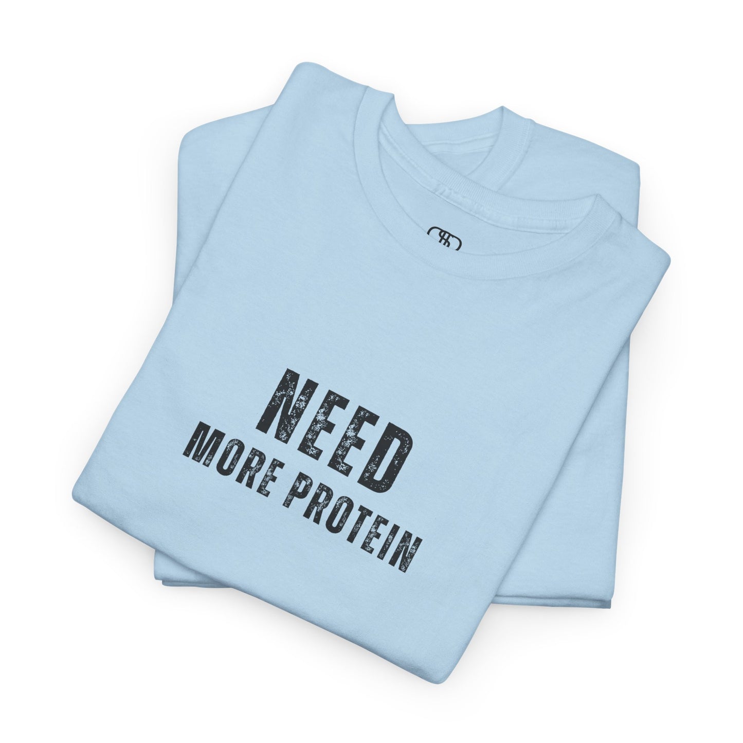 A folded light blue t-shirt with the words “Need Protein” in a large grunge font.