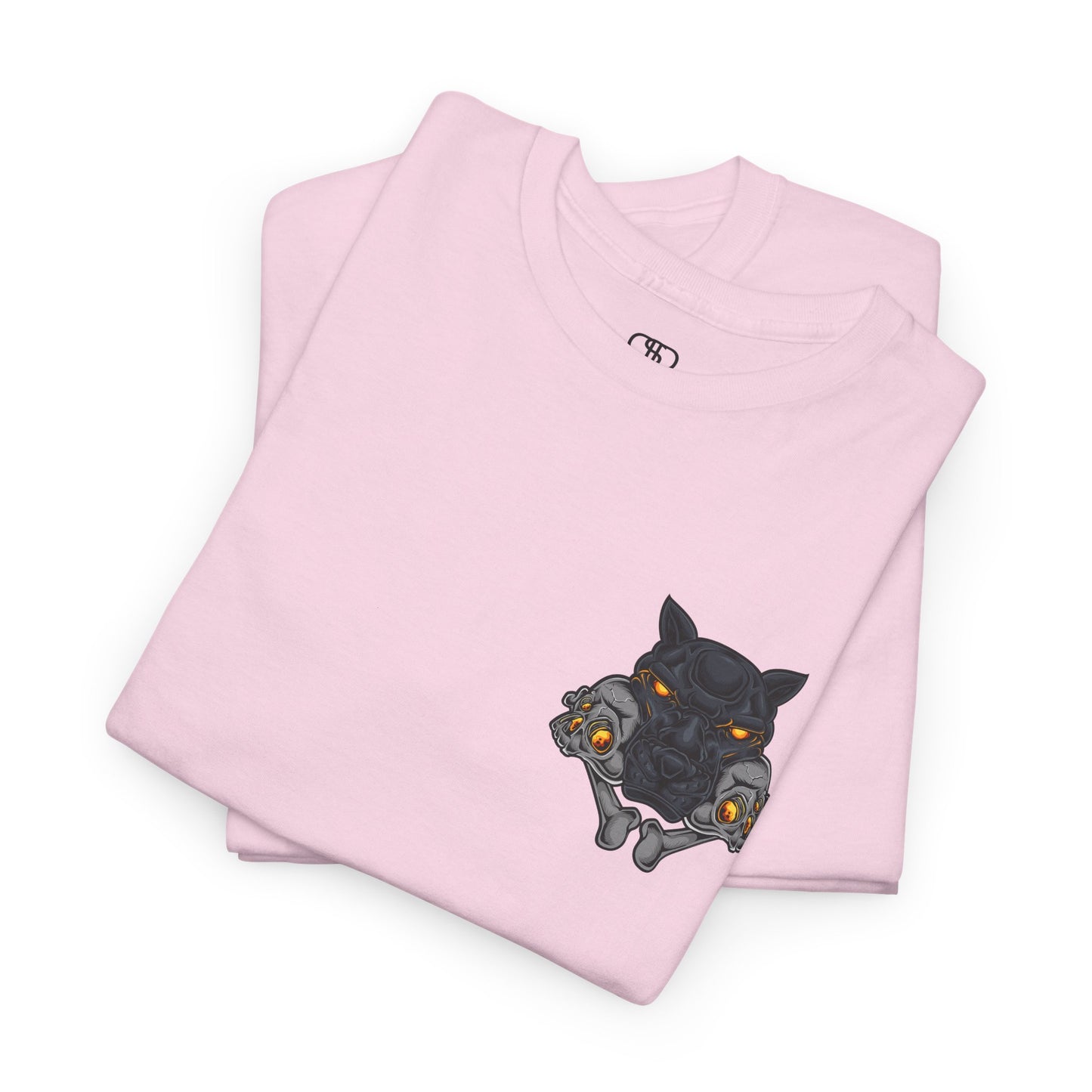 A folded light pink T-shirt with a daring dog graphic biting two skulls, all with glowing molten lava-like eyes.