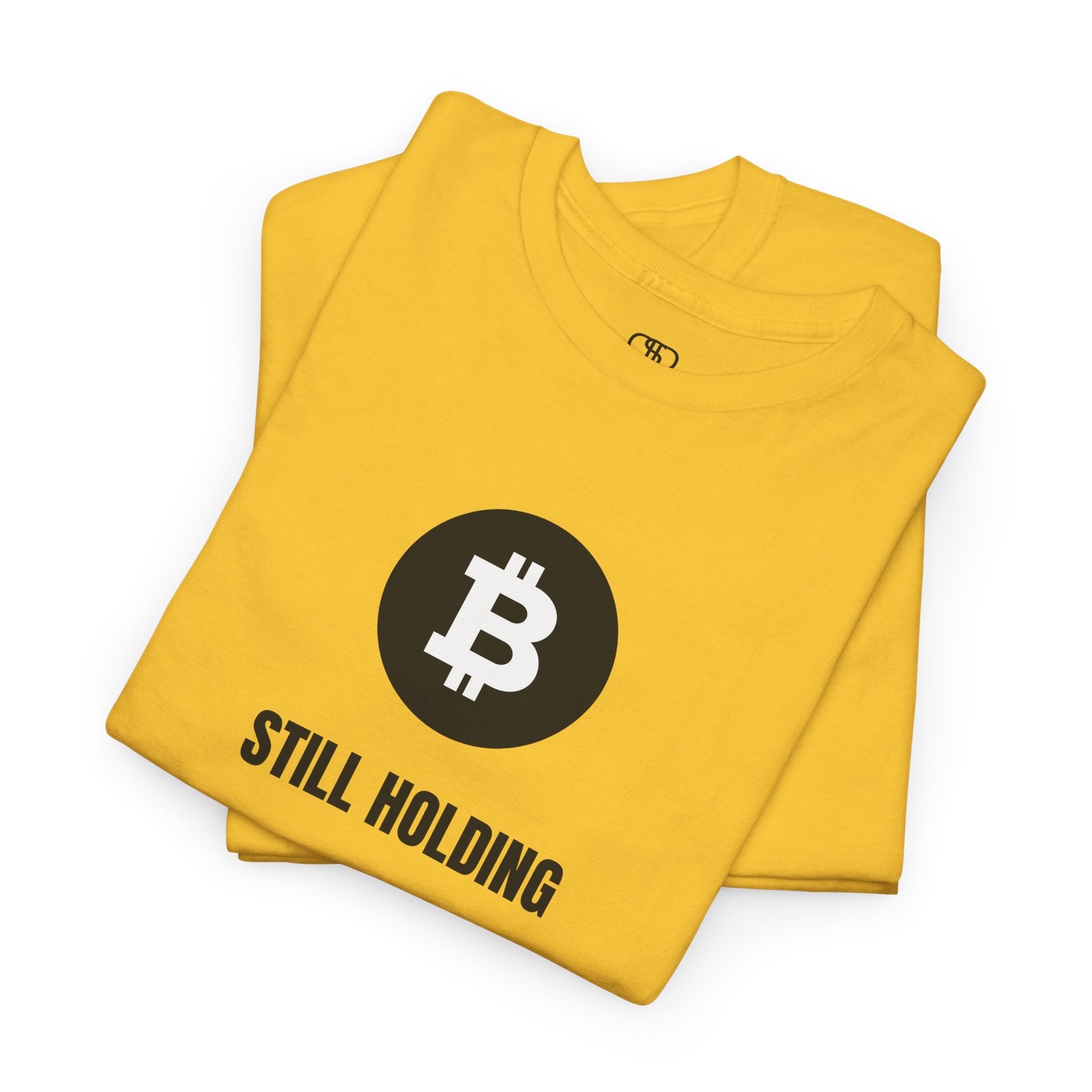 A folded daisy YELLOW T-shirt with a Bitcoin emblem and "Still Holding" text in black.