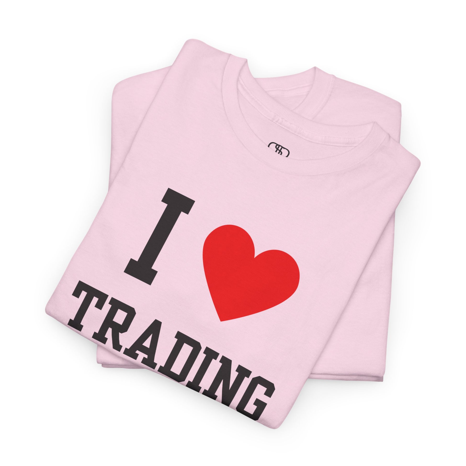 A minimalist folded light pink t-shirt featuring the "I Love  design with the text "I," a red heart symbol, and the word "Trading" underneath.