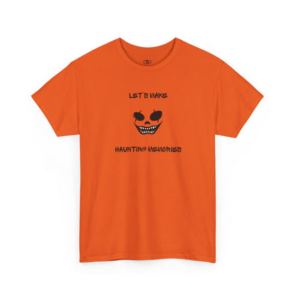 An orange T-shirt with a daring clown graphic with sharp teeth and scars, and "Let’s Make Haunting Memories" text.