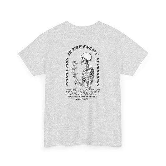 An [Ash gray] t-shirt with a central skeleton and rose design and the words “Perfection is the enemy of progress” and “Bloom” on the front.