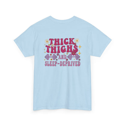 A [light blue] t-shirt with the phrase "Thick Thighs and Sleep Deprived" in a retro font on the front left and enlarged on the back.