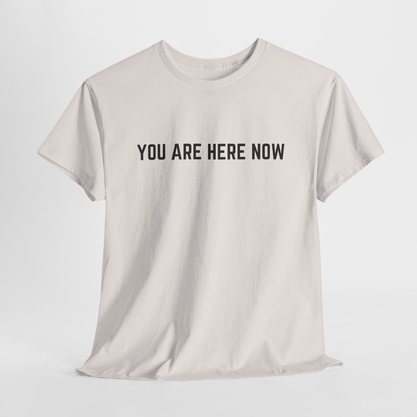 Front of a t-shirt with the grounding phrase "You are Here now" in a clean, minimalist font.