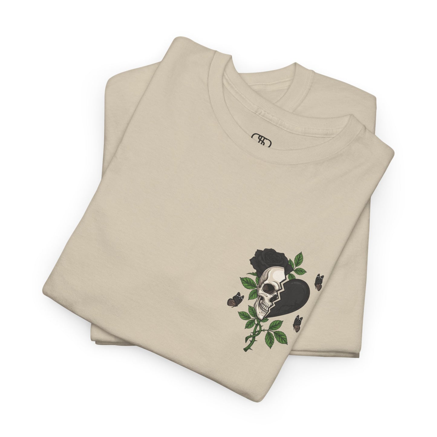 A folded sand t-shirt with a front design of a half skull, half broken heart, and a rose. The back reads "Gym Heals" in black.