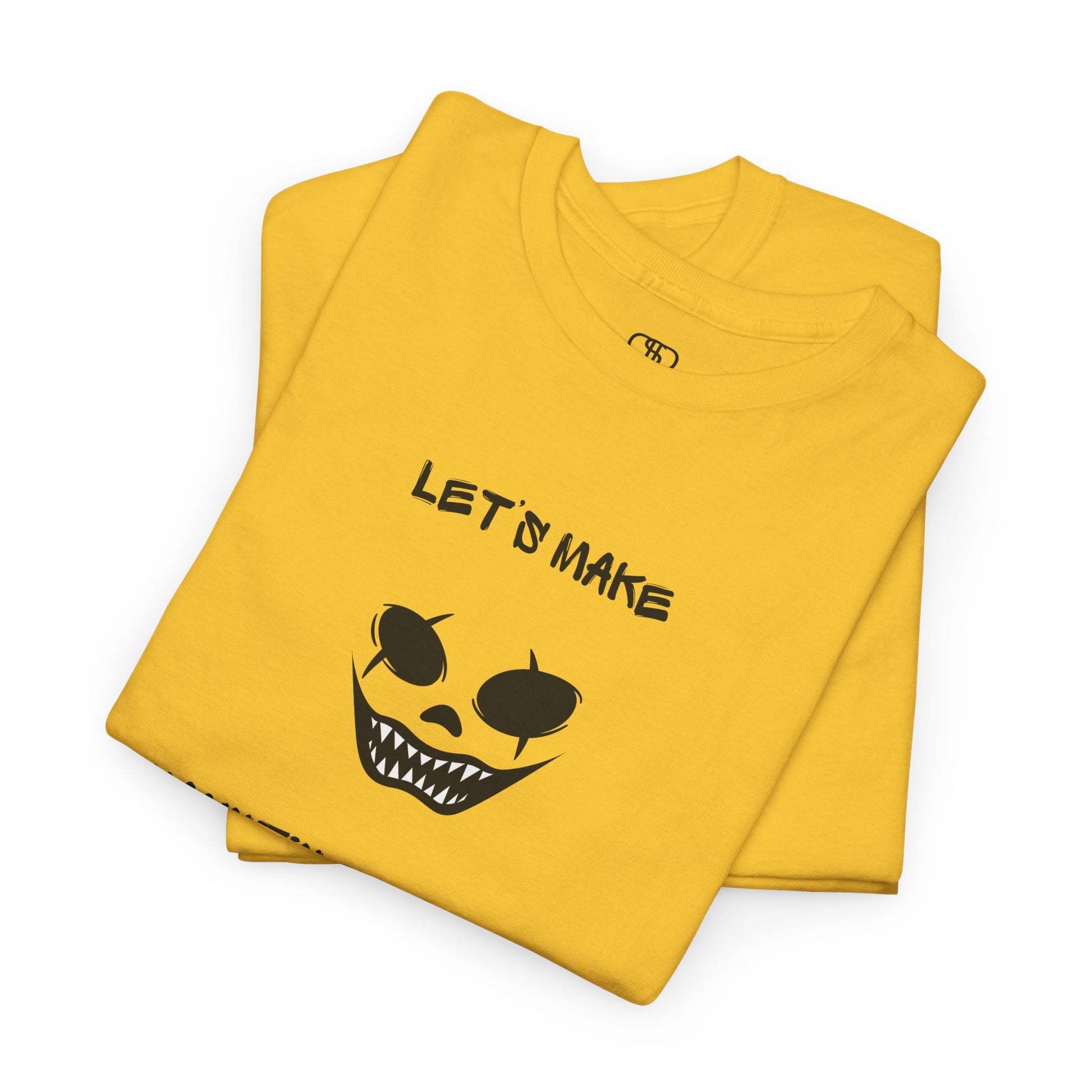 A folded daisy yellow T-shirt with a daring clown graphic with sharp teeth and scars, and "Let’s Make Haunting Memories" text.