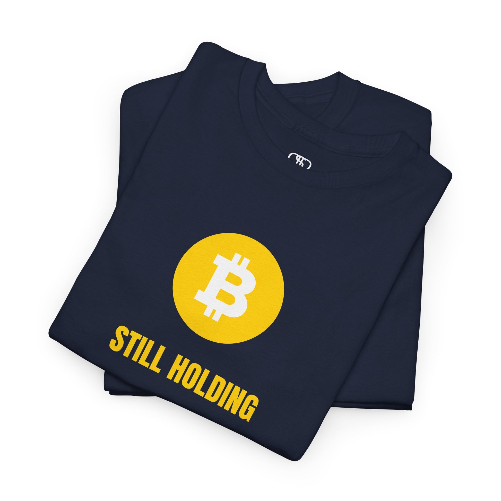A folded  T-shirt with a Bitcoin emblem and "Still Holding" text in gold.