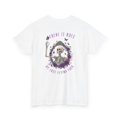 A white t-shirt with a skeleton hand flipping its middle finger on the front surrounded by vines, roses, & butterflies, and a full skeleton design on the back with the phrase “My Last Flying Fuck.”