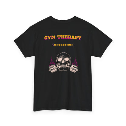 A folded black t-shirt with a skull lifting a barbell on the front and the words “Gym Therapy In Session” with the same skull on the back.